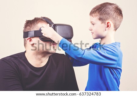 Father and son trying VR glasses at home.