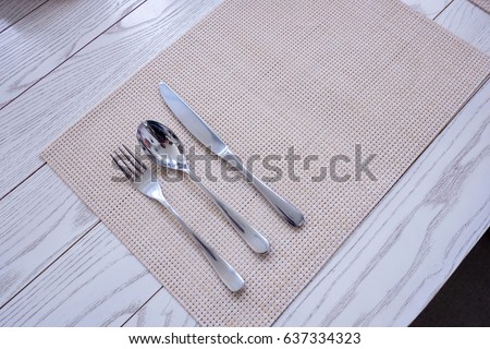 stainless fork and spoon and knife on wood mat textured background