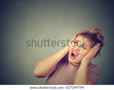 Stressed frustrated woman covering her ears with hands