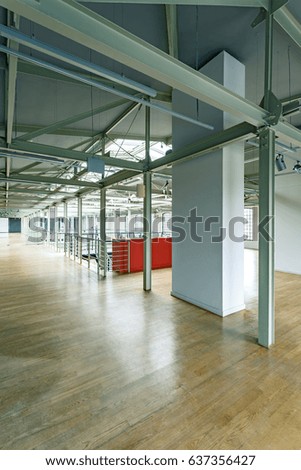 Industrial modern interior of spacious renewed factory with wooden parquet