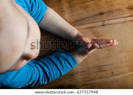 Child hands folded for prayer on wood table