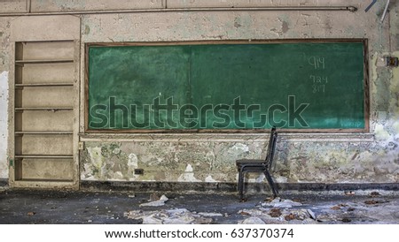 School desk in front of chalkboard in an abandoned school 2