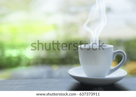 Hot coffee with blur in nature background.