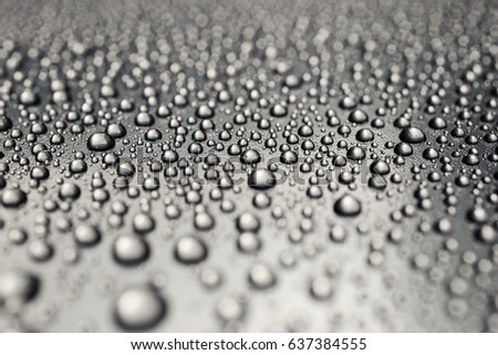 Silver drops on rough surface, abstract background