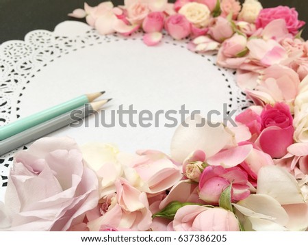 flower petal wreath on paper lace background. flower poetry. concept shabby background with pencils. 