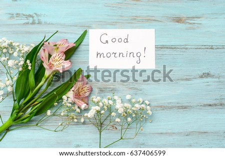 
Flowers and the inscription "Good Morning" on a wooden, turquoise background. The concept of happiness and joy.