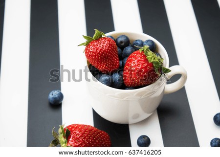 Strawberries and blueberries in a cup on a table