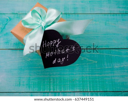 gift box, composition for mother's day on a blue wooden background, space for text.
