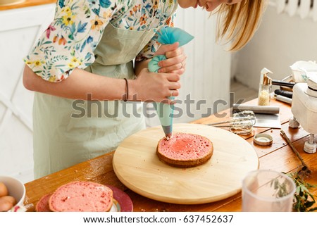 Young girl cooking a strawberry cake in the kitchen