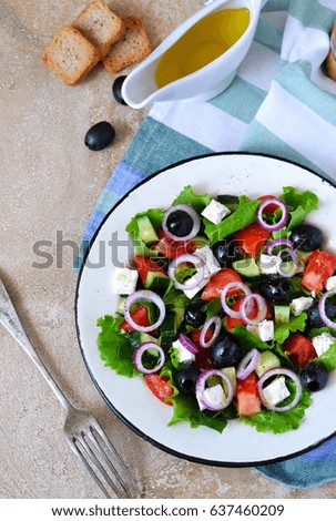 Classic Greek salad with sauce on a concrete background. Greek cuisine.