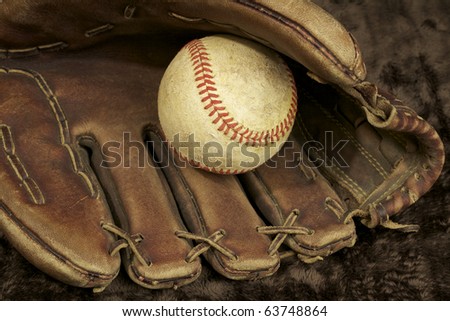 Baseball and glove, showing signs of wear. Studio shot. horizontal shot.