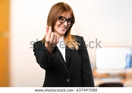 Young business woman making money gesture on unfocused background