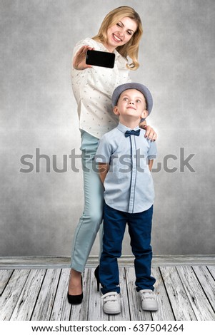 Mother and son take a selfie photo on their mobile phone.Stylish,trendy,modern	