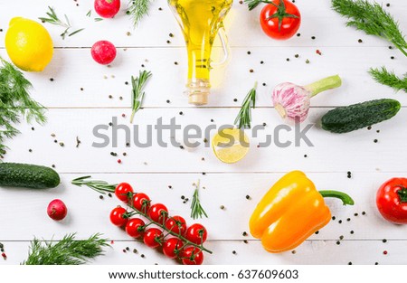 Cucumbers, radish, tomatoes cherry, olive oil, herb and spices on old white wooden background. Set for healthy foods. Ingredients for salad