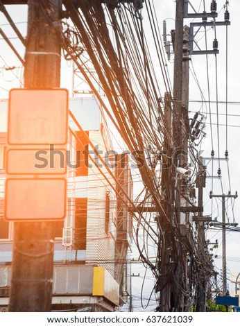 Thailand very messy wires. Dangerous electrical wiring with CCTV camera on electric pole in the city, Including high voltage power electrics, phone communication cable tangled and small billboards.
