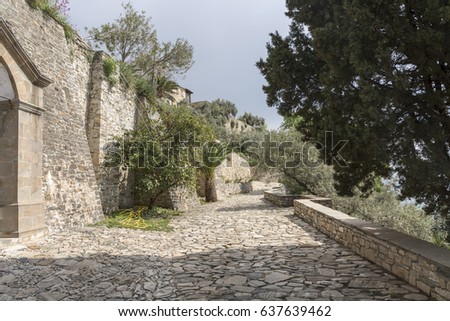 Cobblestone road near stone walls, at seaside, in Greece, on The Holy Athos Mountain. Spring time.
