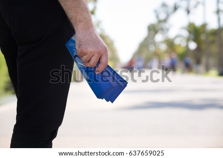 Christian Man Distributing Evangelistic Flyers in The Park Royalty-Free Stock Photo #637659025
