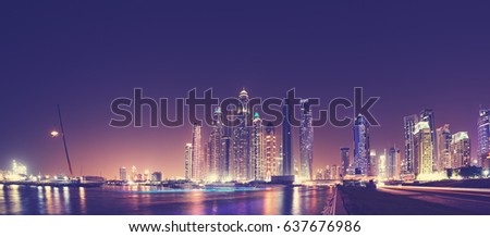 Fisheye lens panoramic picture of Dubai waterfront skyline at night, color toning applied, United Arab Emirates.