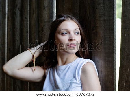 close-up of beautiful woman against a old wooden wall