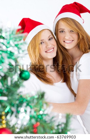 happy young friends behind Christmas tree