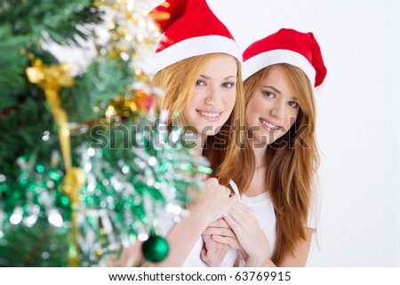 happy young friends behind Christmas tree