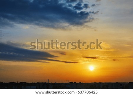 Sunrise, sky with clouds over silhouettes of houses morning city.