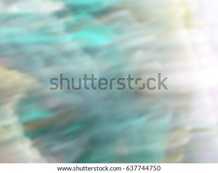 Blurred photo in pale cold green colors with movement effect.