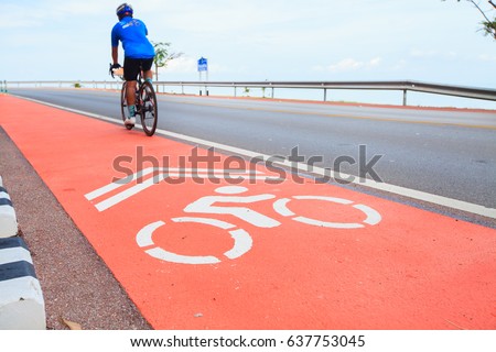 White bike road sign on red asphalt.Bike lanes along the coastline have cyclists to spin the workout.