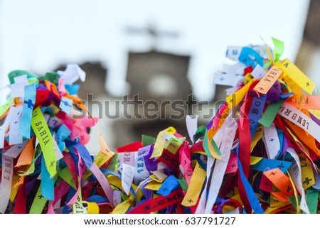 Colorful votive ribbons "Souvenir from Bahia" in church grid Nosso Senhor do Bonfim with the church blurred in the background in Salvador, Bahia, Brazil.