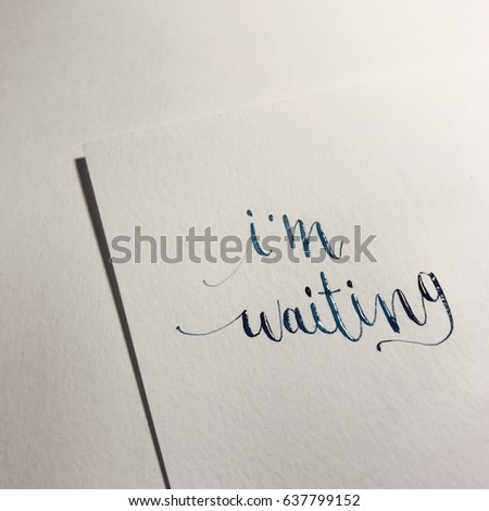 Dip pen calligraphy. word ' I,m waiting ' . The freehand writing word on paper.