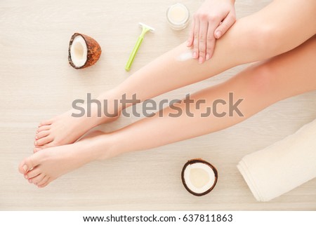 Woman applying coconut oil on legs, closeup Royalty-Free Stock Photo #637811863