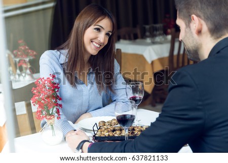 Portrait of couple eating can of snails in the restaurant.