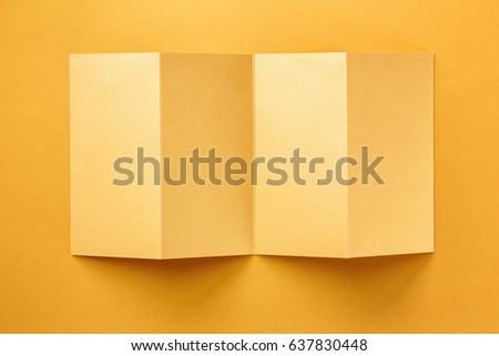 Mockup of opened four fold golden brochure isolated at foil background.