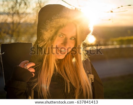Happy girl tourist at sunset with backpack. Half-length portrait. Adventure, travel