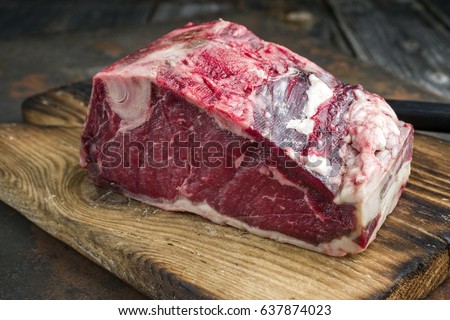 Raw dry aged Rib of Beef as close-up on an old cutting board Royalty-Free Stock Photo #637874023