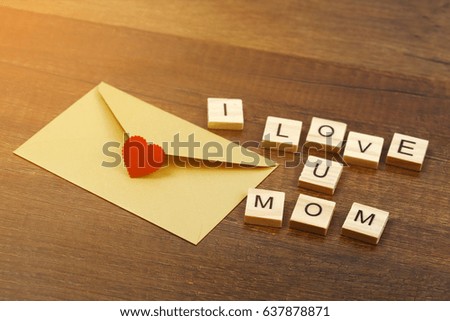 I love mom wording with red heart sign and gold envelope on old wooden background, Mother's day concept.