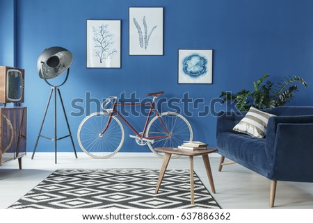 Cozy blue and white loft interior with sofa and bicycle