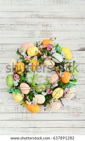 Decoration from easter eggs in shape of circle on painted wooden background