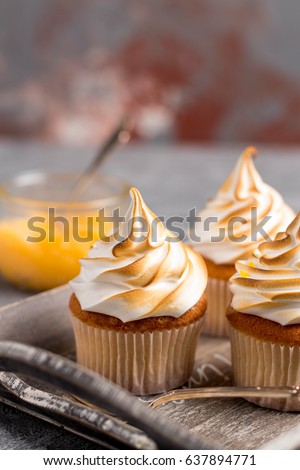 Lemon cup cakes with cream on a gray background