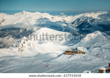 View from the top of a mountain, with skiers and restorant in a distance, France, La Plagne Royalty-Free Stock Photo #637914658