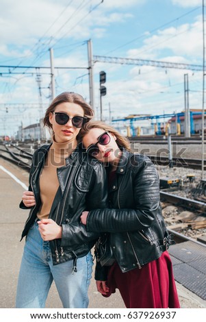 Beautiful fashion women posing. Trendy lifestyle urban portrait on city background.stylish girlfriend in sunglasses at the railway station