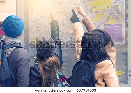Tourists at  the map of Paris looking for the way 
