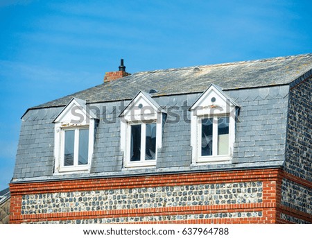 photo of beautiful roof of one on the buildings on the wonderful sunny sky background, France, Normandy