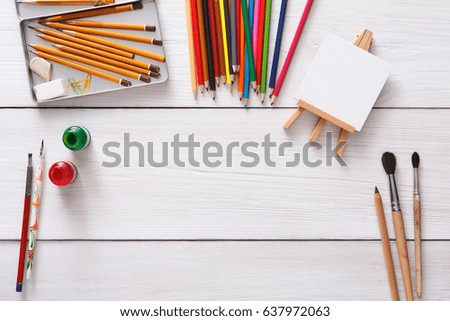Artist workspace. Drawing tools, stationary supplies, workplace of artist. Watercolor paints and blank paper on white wooden desk, top view, flat lay, copy space