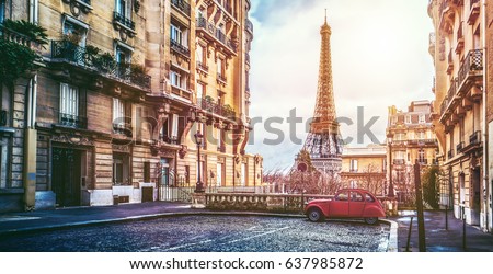 small paris street with view on the famous paris eifel tower on a cloudy rainy day with some sunshine Royalty-Free Stock Photo #637985872