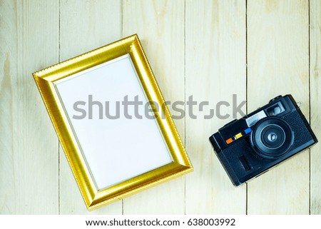 Old camera and frame on wooden