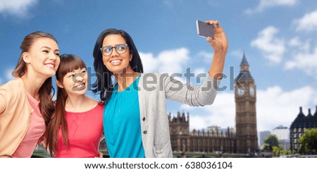 travel, tourism and people concept - international group of happy smiling different women taking selfie with smartphone over london city background