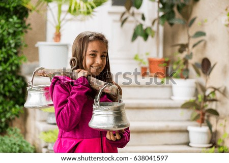 Little girl from Bulgaria with a traditional water carrying tool called "kobilitsa"