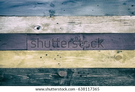 Rustic wood panel background of weathered and faded blue, white, purple, yellow and b lack color washed panels