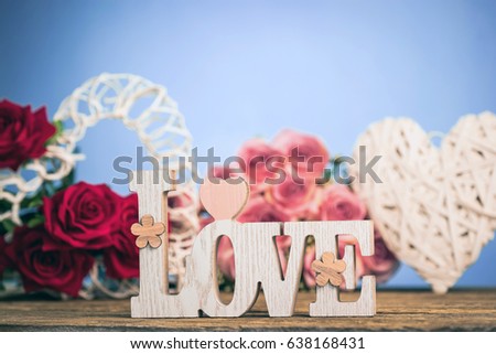 Red roses flowers with wooden word LOVE on wooden background with place for text. Romantic Valentines holidays concept. Valentine's day greeting card.. Copy space.